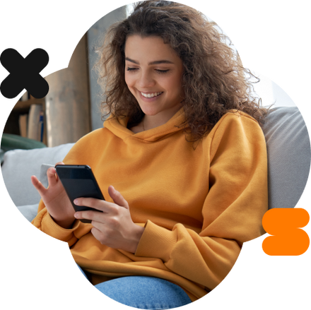 Mulher com uma jaqueta laranja utilizando o app do Inter em seu celular.