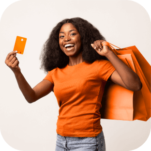 Mulher sorridente ao mostrar seu cartão de crédito Inter e sacolas de compras.